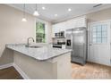 Modern kitchen with white cabinets, granite countertops, and stainless steel appliances, with a door on the right side at 1735 15Th Street Ne Pl, Hickory, NC 28601
