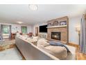 Inviting living room featuring a brick fireplace, plush sofa, and hardwood floors at 174 Wintergreen Cir, Statesville, NC 28677