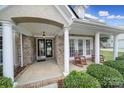 Inviting front porch with white columns, rocking chairs, and well-maintained landscaping creates a cozy and welcoming entrance at 2218 Legacy Oak Dr, Waxhaw, NC 28173