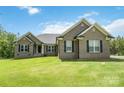 Well-maintained home with a green lawn and a front entrance showing black door and covered porch at 2489 Highway 161 S Hwy, York, SC 29745