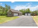 A detached two-car garage and a barn with an outdoor basketball court in a backyard at 2489 Highway 161 S Hwy, York, SC 29745