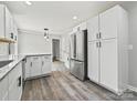 Spacious kitchen featuring stainless steel appliances, modern white cabinetry, granite counters, and stylish flooring at 2544 Cedarwild Rd, Charlotte, NC 28212