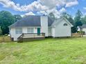 A view of the spacious backyard with a wooden deck, white siding, and a fenced yard at 3776 Kennedy Rd, Gastonia, NC 28056
