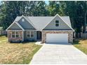 Craftsman style home with green siding, stone accents, attached two-car garage, and a concrete driveway at 4049 Fincher Rd # 3, Matthews, NC 28104