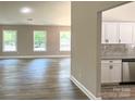 Spacious living room featuring hardwood floors, three large windows, and a view into the modern kitchen at 4049 Fincher Rd # 3, Matthews, NC 28104