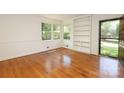 Bright living room with hardwood floors, built-in shelving, and large windows overlooking the yard at 4361 Applegate Rd, Charlotte, NC 28209