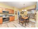 Cozy dining area with wood cabinets, stainless steel appliances, and a decorative chandelier at 4405 Sugar Cane Ct, Waxhaw, NC 28173