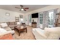 Bright living room featuring large windows with decorative curtains, plush seating, and a ceiling fan at 4405 Sugar Cane Ct, Waxhaw, NC 28173