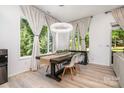 Dining room with wood table, modern chandelier, and bright windows overlooking greenery at 4608 Rockwood Dr, Waxhaw, NC 28173