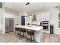 Sleek, modern kitchen with white cabinets, stainless steel appliances, island with bar stools, and pantry at 4608 Rockwood Dr, Waxhaw, NC 28173