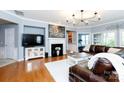 Spacious living room features hardwood floors, plush rug, fireplace, and an entertainment center at 52538 Winchester St, Fort Mill, SC 29707