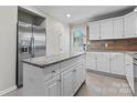 Modern kitchen boasts stainless steel appliances, granite countertops, and a stylish island at 606 Deer Creek Dr, Matthews, NC 28105