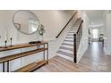 Foyer featuring wood floors, stairs, console table with a round mirror, and white trim at 6176 Russo Ct, Lancaster, SC 29720