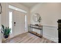 Bright foyer with wood floors, console table, round mirror, and a white front door at 6176 Russo Ct, Lancaster, SC 29720