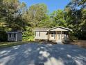 Exterior shot of gray house with gray outbuilding and large gravel driveway at 654 Old Nc 515 Hwy, Wadesboro, NC 28170