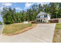 Exterior view of the white home featuring a long driveway and fenced backyard at 658 Morgan Rd, Albemarle, NC 28001