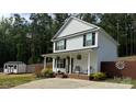 Charming two-story home featuring a cozy front porch with rocking chairs and manicured landscaping at 658 Morgan Rd, Albemarle, NC 28001