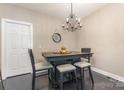 Dining room with modern chandelier, table with chairs and dark wood floor at 6912 Park Place Dr, Charlotte, NC 28262