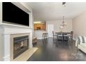 Open concept living room with fireplace, modern floors, and view of the kitchen at 6912 Park Place Dr, Charlotte, NC 28262