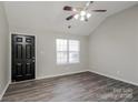 Bright living room featuring high ceilings, a ceiling fan, attractive gray floors, and a black front door at 7830 Lobilia Ln, Charlotte, NC 28214