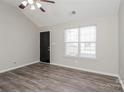 Bright living room featuring high ceilings, a ceiling fan, attractive gray floors, and a black front door at 7830 Lobilia Ln, Charlotte, NC 28214