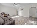 Open concept living room with wood floors, neutral walls, ceiling fan, and comfortable brown leather furniture at 804 Allen Dr, Marshville, NC 28103