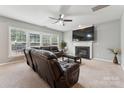 Comfortable living room with plush leather sofas, a fireplace, and a large screen television at 8709 Barrelli Ct, Charlotte, NC 28277