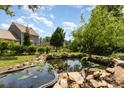 Backyard pond with water lilies is framed by rocks and mature landscaping at 109 Arabian Ln, Salisbury, NC 28147