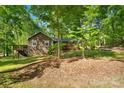 View of a cozy home with a wooden deck, nestled amongst lush greenery and mature trees at 110 Lakeland Rd # 19, Mooresville, NC 28117