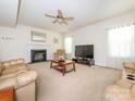 Inviting living room with a fireplace, ceiling fan, and comfortable seating, perfect for relaxing and entertaining at 12304 Lookout Point Dr, Charlotte, NC 28269
