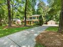 Traditional two-story home with green shutters, surrounded by mature trees and a long driveway leading to a detached garage at 1325 Rock Point Rd, Charlotte, NC 28270