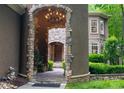 Grand entrance with stone archway, chandelier, and lush landscaping leading to the front door at 135 Sumter Dr, Mooresville, NC 28117