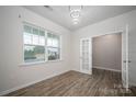 Bright living room with hardwood floors, large window, modern light and glass French doors at 150 Falls Cove Dr, Troutman, NC 28166