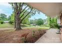 Lush front yard view showcasing mature trees and landscaping from a covered porch at 1521 19Th Sw St, Hickory, NC 28602