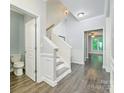 Bright foyer with hardwood flooring, staircase, and views into adjacent rooms at 17219 Grand Central Way, Cornelius, NC 28031