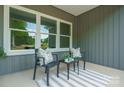 Inviting front porch with seating area featuring neutral-colored pillows and striped rug at 175 Lone Pine Rd, Statesville, NC 28625