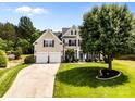 Beautifully landscaped two-story home with a spacious lawn, mature tree, and convenient two-car garage at 1900 Birchbrook Ct, Harrisburg, NC 28075