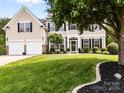 Lovely two-story home with a well-kept lawn, trimmed hedges, and an attached two-car garage at 1900 Birchbrook Ct, Harrisburg, NC 28075