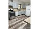 Bright kitchen featuring stainless steel appliances, painted cabinets and wood-look floors at 2030 Keisler Dairy Rd, Conover, NC 28613