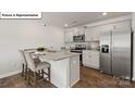 Stylish kitchen island offers additional seating, granite countertops, and stainless steel appliances at 2905 Penninger Cir, Charlotte, NC 28262