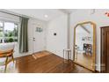 Bright foyer showcasing hardwood floors, a statement mirror, and a white front door with glass panels at 2933 Hilliard Dr, Charlotte, NC 28205