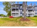 Multi-story condo building with balconies overlooking a lush lawn and waterfront, blending nature with modern living at 372 Northwest Dr, Davidson, NC 28036