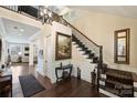 Inviting foyer featuring beautiful hardwood floors, staircase, and a decorative chandelier at 4122 Banfield Pl, Charlotte, NC 28226