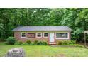 Charming brick home with metal roof, manicured landscaping, and decorative window accents at 4705 Campground View Rd, Catawba, NC 28609