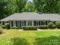 Straight-on view of the house with a green lawn and mature shrubbery framing the property at 532 Courtney Ln, Matthews, NC 28105