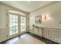 View of the foyer showcasing a decorative rug, tiled floor, an ornate table and a set of sconces at 532 Courtney Ln, Matthews, NC 28105