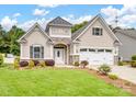 Charming home featuring stone accents, a two-car garage, manicured lawn and a covered front porch at 581 Harrison Nw Dr, Concord, NC 28027