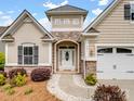 Inviting home exterior showcasing stone details, a two-car garage, and a well-manicured front yard at 581 Harrison Nw Dr, Concord, NC 28027