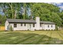 Inviting home with a lush green lawn, accented by dark mulch beds, and a prominent chimney feature at 6301 Vernedale Rd, Charlotte, NC 28212