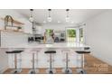 Modern kitchen with stainless steel appliances, white cabinets, a tile backsplash, and a breakfast bar at 6301 Vernedale Rd, Charlotte, NC 28212